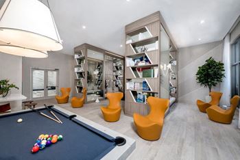 A games room with a pool table and chairs